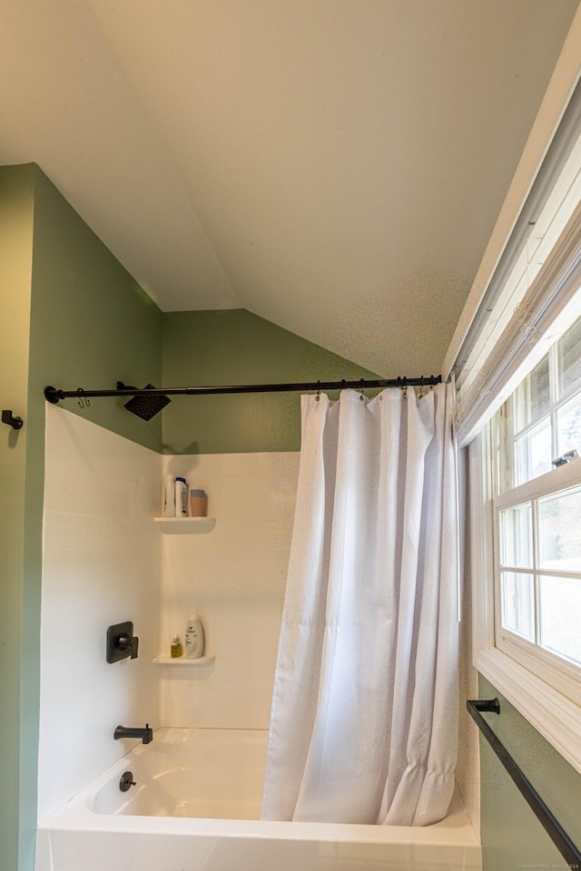 bathroom featuring shower / tub combo and vaulted ceiling