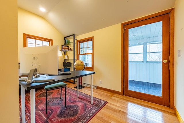 office with lofted ceiling, light wood-type flooring, and a wealth of natural light