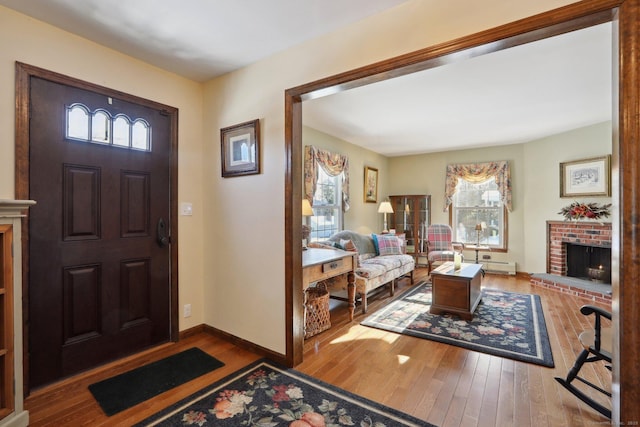 entrance foyer featuring a fireplace, plenty of natural light, and light wood-type flooring