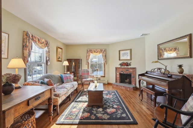 living room with a brick fireplace and light wood-type flooring