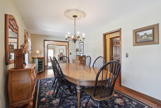 dining space featuring hardwood / wood-style floors and a chandelier