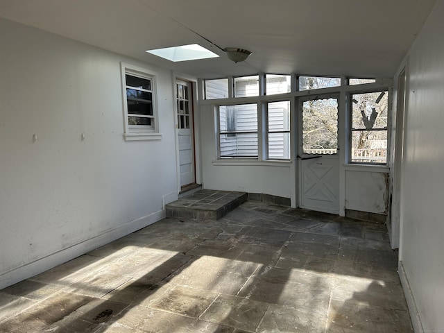 empty room with lofted ceiling with skylight