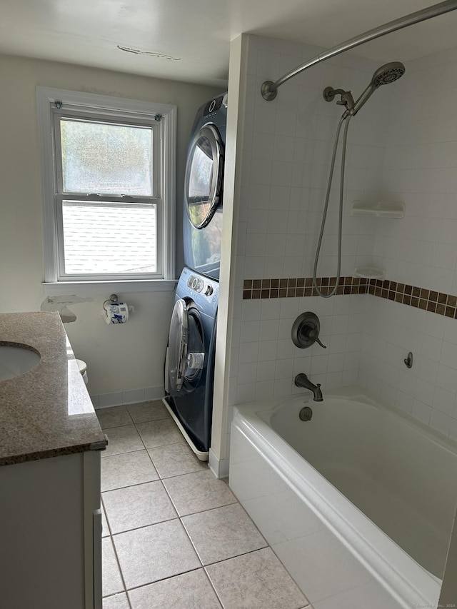 bathroom featuring vanity, tile patterned floors, tiled shower / bath, and stacked washer / dryer