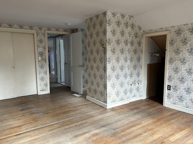 unfurnished room featuring vaulted ceiling and light wood-type flooring