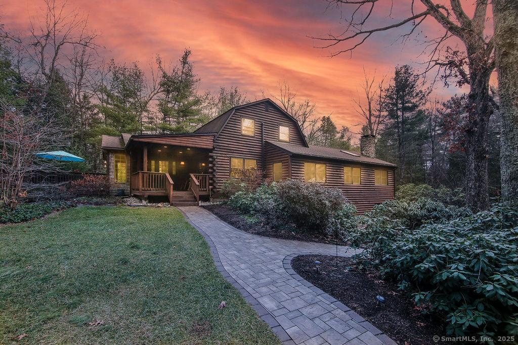 back house at dusk with a lawn