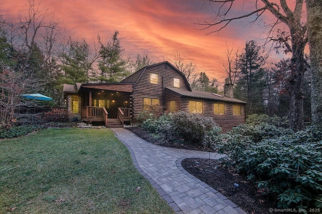 back house at dusk with a lawn