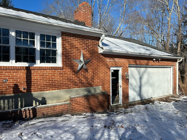 view of snow covered exterior with a garage