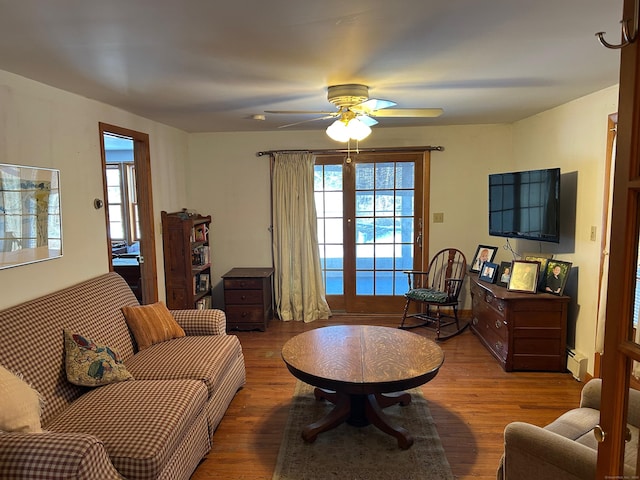 living room featuring a baseboard radiator, hardwood / wood-style flooring, and ceiling fan