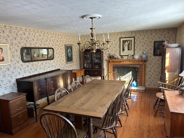 dining room featuring hardwood / wood-style floors, a chandelier, and a textured ceiling