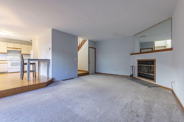 unfurnished living room with light colored carpet