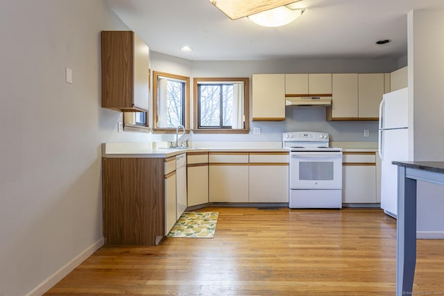 kitchen featuring sink, light hardwood / wood-style flooring, white appliances, and cream cabinetry