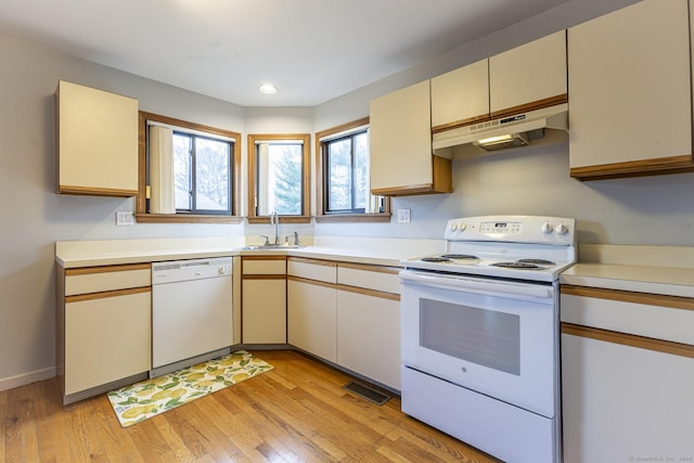 kitchen featuring cream cabinets, sink, white appliances, and light hardwood / wood-style flooring