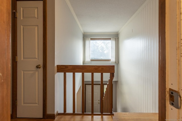 stairs with a textured ceiling and crown molding