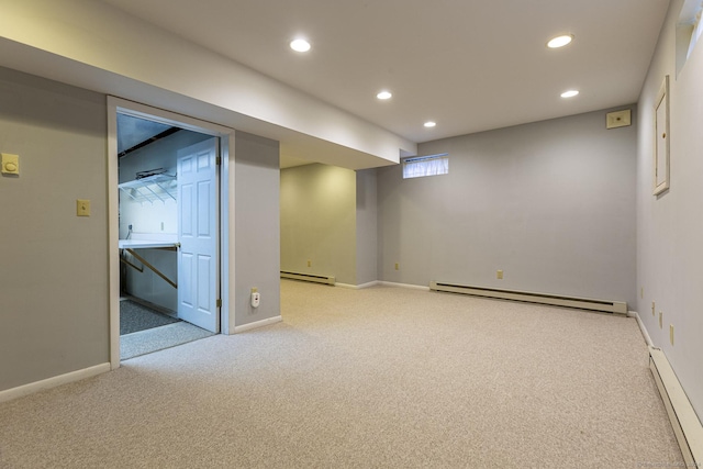 basement with light colored carpet and a baseboard heating unit