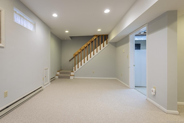 basement featuring carpet flooring and a baseboard heating unit