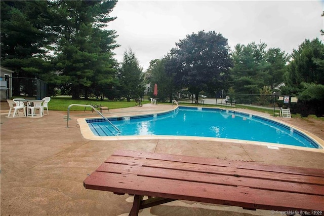 view of pool with a lawn and a patio area