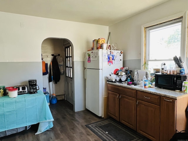 kitchen featuring dark hardwood / wood-style floors, white refrigerator, dark brown cabinetry, and sink