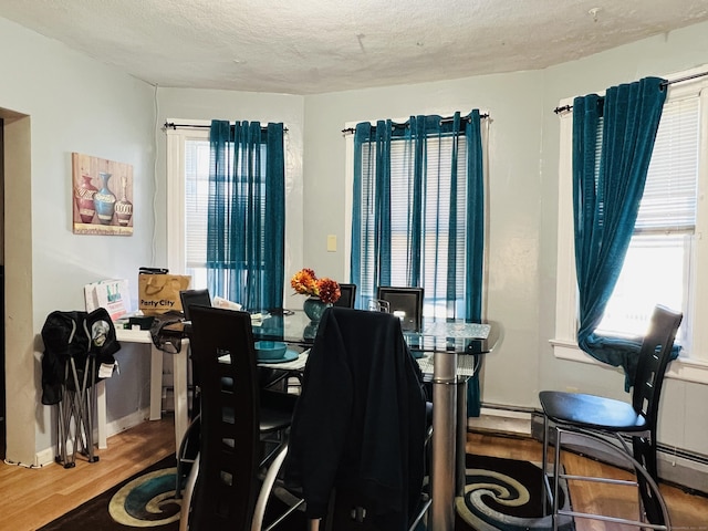 dining room featuring hardwood / wood-style floors and a textured ceiling