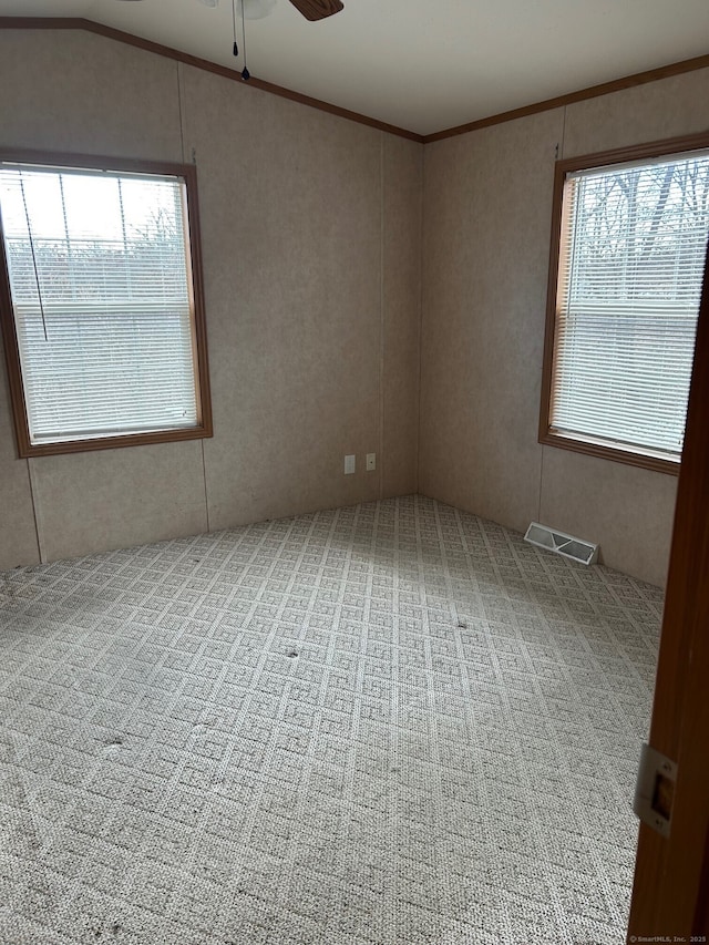 empty room with carpet flooring, ceiling fan, and crown molding