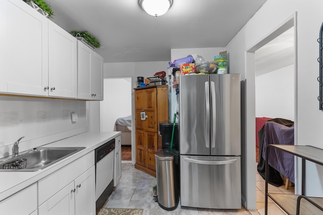 kitchen featuring dishwasher, sink, backsplash, stainless steel fridge, and white cabinets