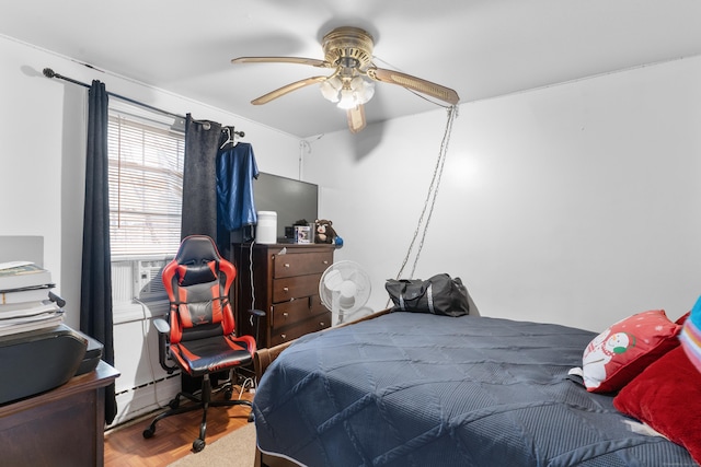 bedroom featuring ceiling fan, parquet flooring, and a baseboard radiator