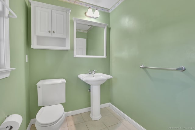 bathroom with tile patterned floors, crown molding, and toilet