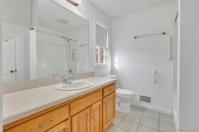 bathroom with tile patterned floors, vanity, toilet, and walk in shower