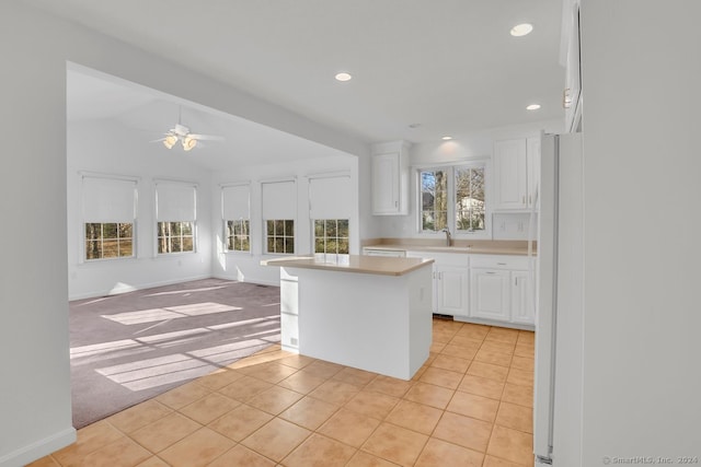 kitchen with white cabinetry, a kitchen island, and light tile patterned floors