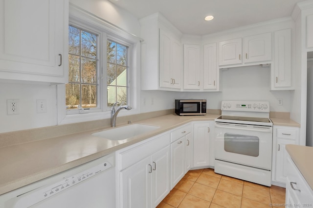 kitchen with sink, white cabinets, light tile patterned flooring, and white appliances