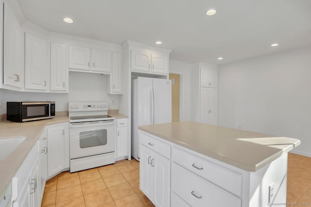 kitchen featuring white cabinets, a center island, white appliances, and light tile patterned floors