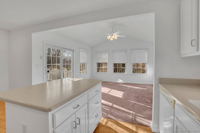 kitchen with dishwasher, light carpet, white cabinets, and lofted ceiling