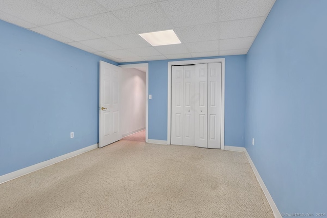 unfurnished bedroom featuring a drop ceiling and a closet