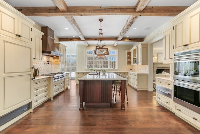 kitchen with pendant lighting, a kitchen bar, and cream cabinetry