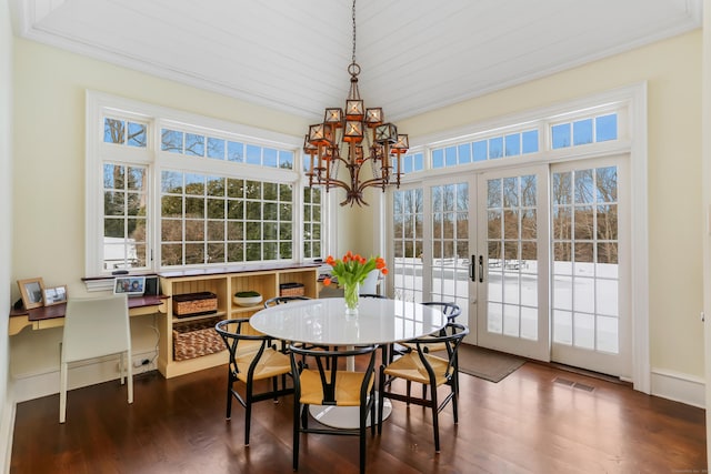 dining area with ornamental molding, a notable chandelier, dark hardwood / wood-style flooring, and french doors