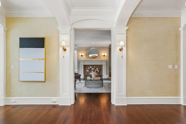 hallway with hardwood / wood-style flooring, ornamental molding, and ornate columns