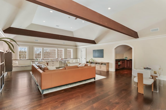 living room with ornamental molding, dark hardwood / wood-style floors, and vaulted ceiling with beams