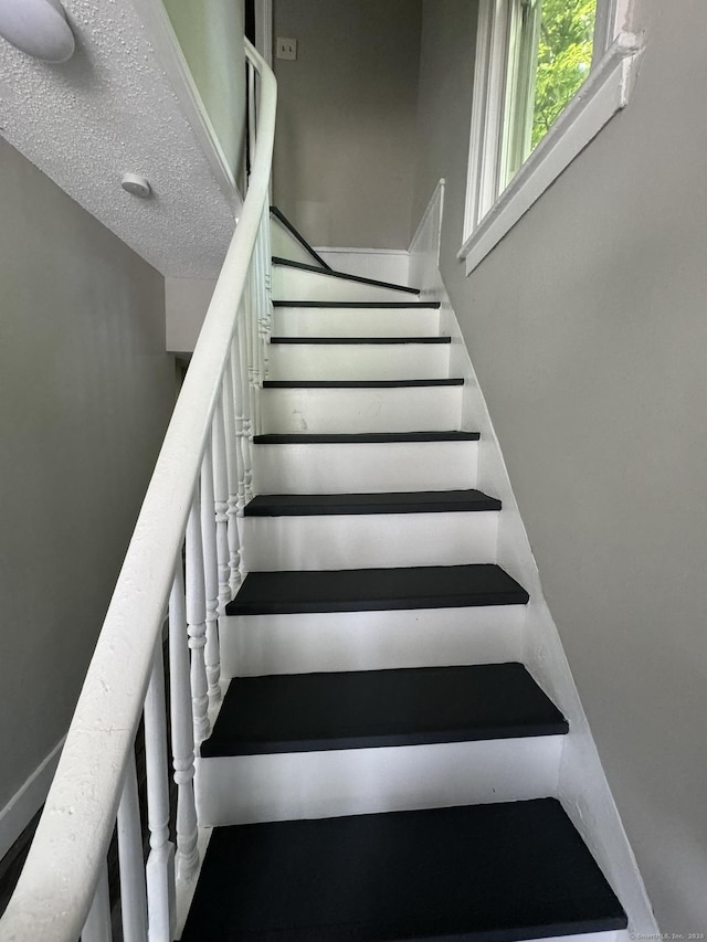 stairway with a textured ceiling