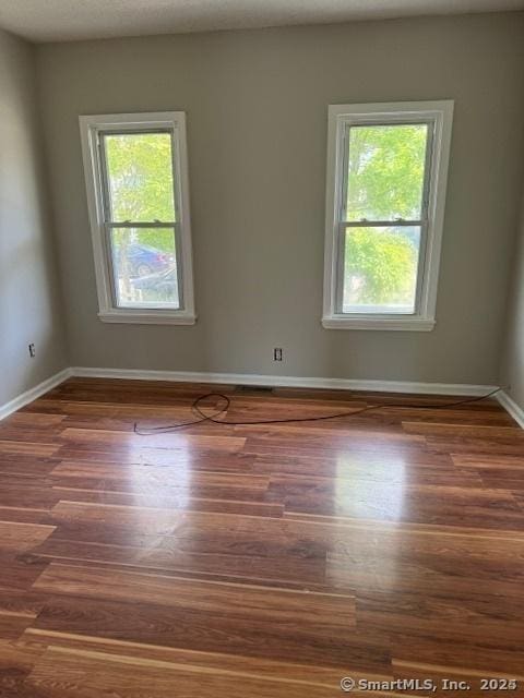 empty room with dark wood-type flooring