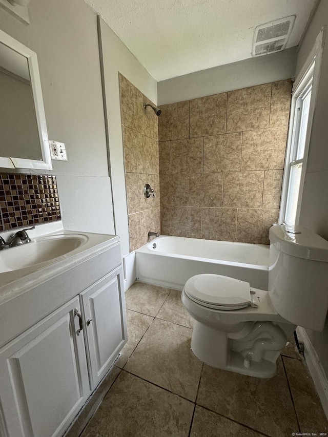 full bathroom with tiled shower / bath combo, tile patterned flooring, toilet, decorative backsplash, and vanity