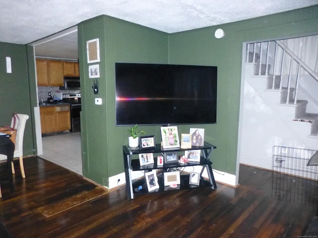 living room featuring a textured ceiling and dark wood-type flooring