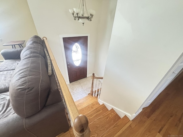 foyer featuring light wood-type flooring and a notable chandelier