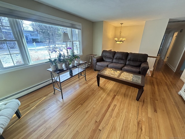 living room featuring a chandelier, plenty of natural light, and light hardwood / wood-style flooring