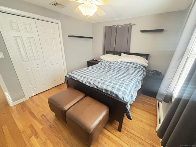 bedroom featuring ceiling fan, light hardwood / wood-style flooring, and a closet