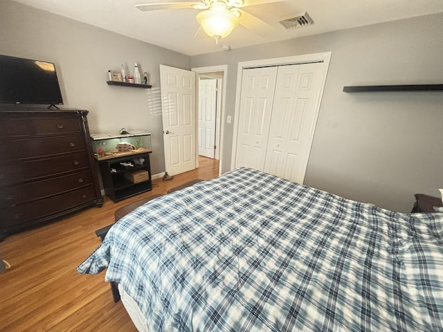 bedroom with hardwood / wood-style flooring, ceiling fan, and a closet