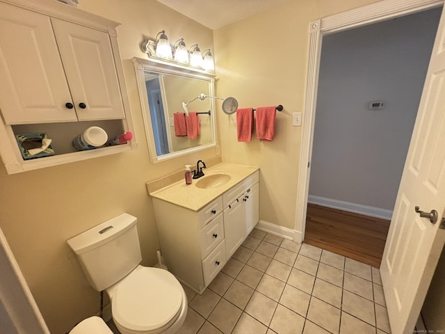 bathroom featuring tile patterned floors, vanity, and toilet