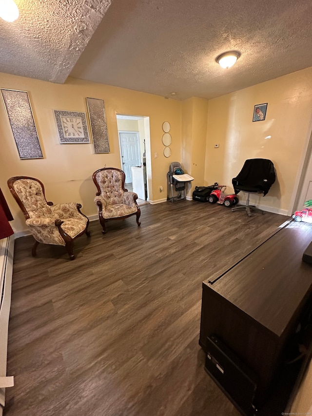 sitting room with dark hardwood / wood-style floors and a textured ceiling