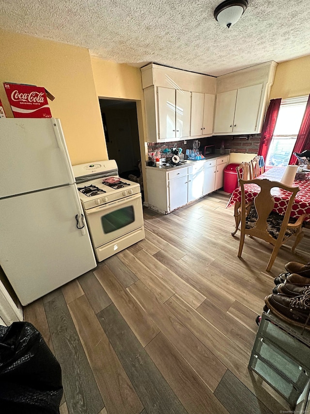 kitchen with white cabinetry, light wood-type flooring, white appliances, and a textured ceiling