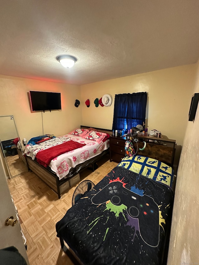 bedroom featuring a textured ceiling and light parquet flooring