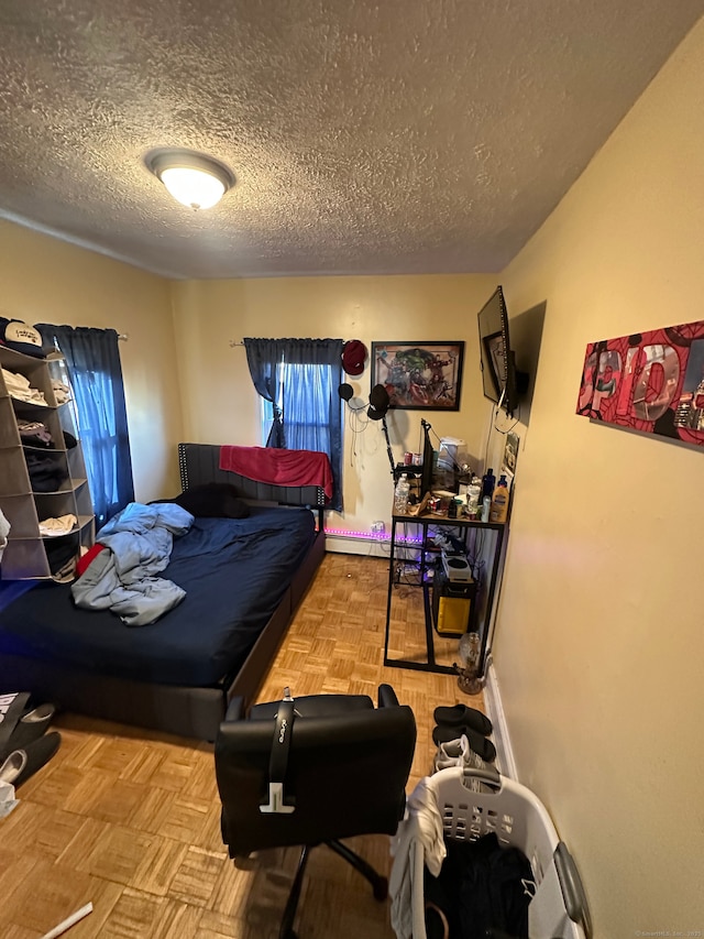 bedroom with parquet floors and a textured ceiling