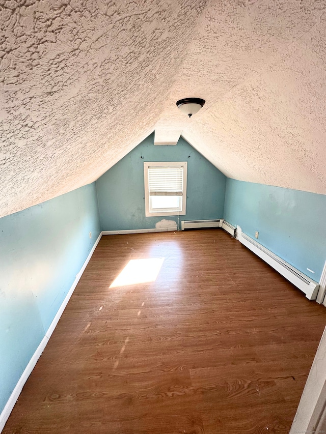 bonus room featuring hardwood / wood-style flooring, vaulted ceiling, a textured ceiling, and a baseboard radiator